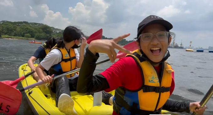 Children paddling in brightly colored kayaks