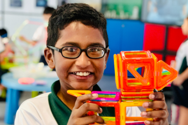 A student stacking colorful blocks